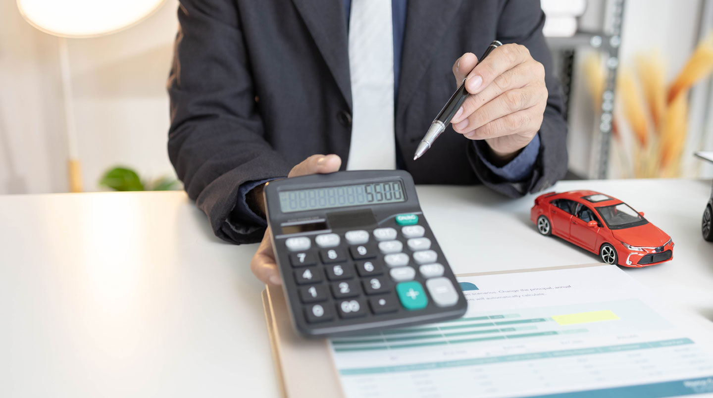 Écran d'ordinateur affichant un tableau de simulation de financement automobile avec colonnes de mensualités et comparaison de durées, clavier visible au premier plan